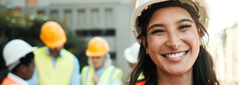 three workers giving a high five; only one's face is clearly visible and he is smiling at the others