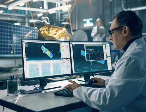 engineer at a desk working on a satellite schematic
